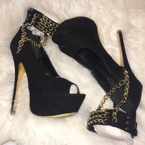 Black high heels with gold chains.